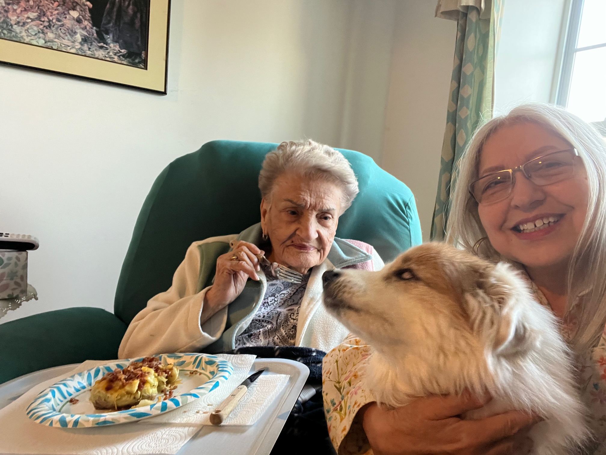 Caregiver sharing conversation and a meal with a senior client at home