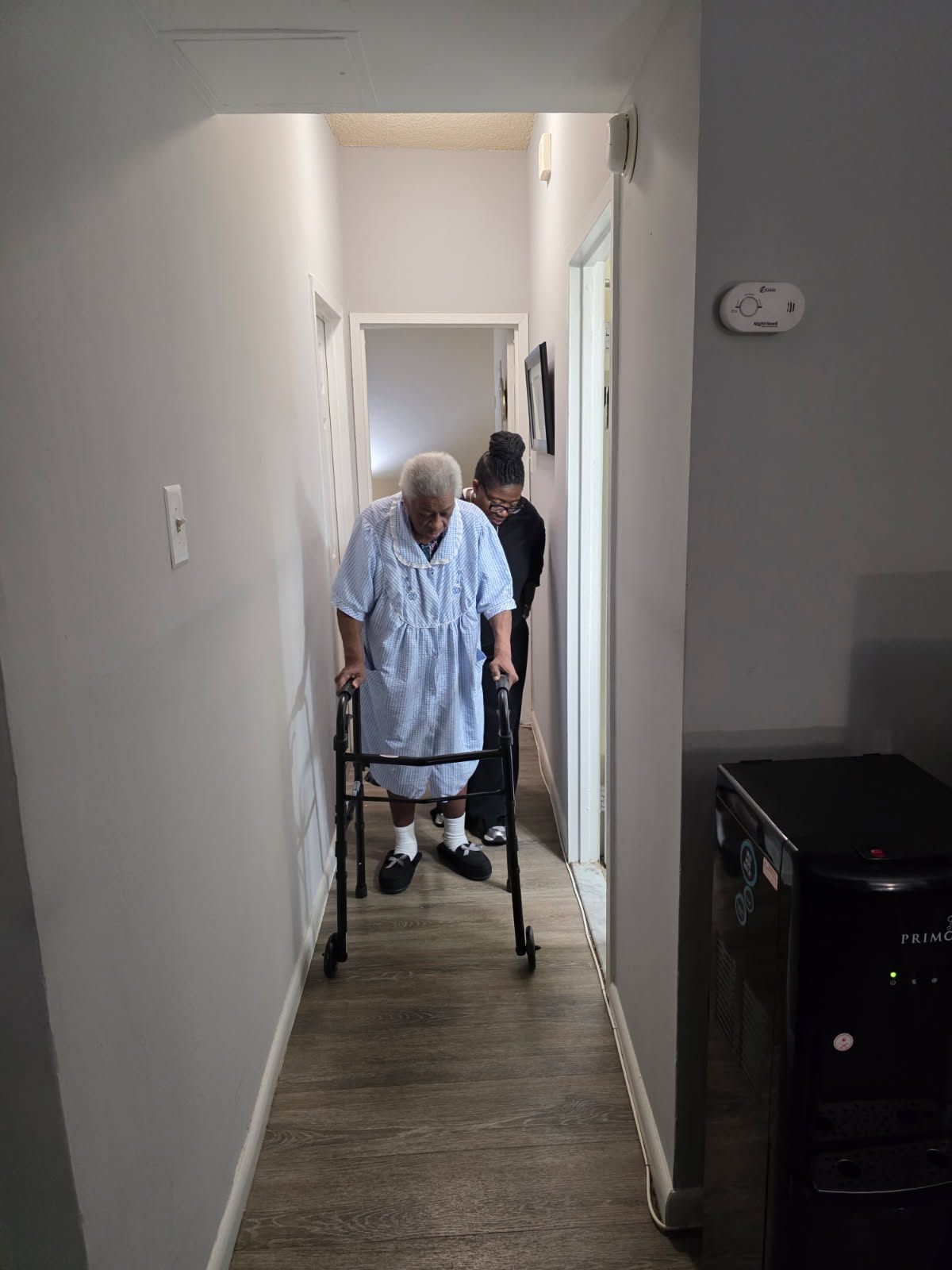 Caregiver helping a senior client with mobility and daily routines at home